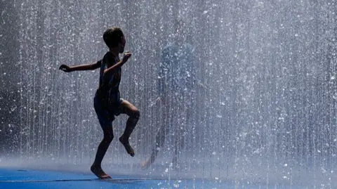 Getty Images A boy runs through a fountain on the South Bank on June 19, 2025 in London, United Kingdom.