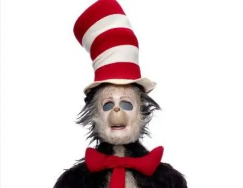 Propstore A screengrab of the original Cat in the Hat suit from the 2003 Mike Myers film, it features a tall red and white top hat and a red tie and is showing noticeable signs of disrepair. 