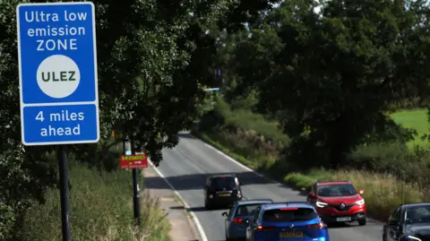 EPA Cars in the countryside passing a ULEZ zone sign that says 4 miles ahead.