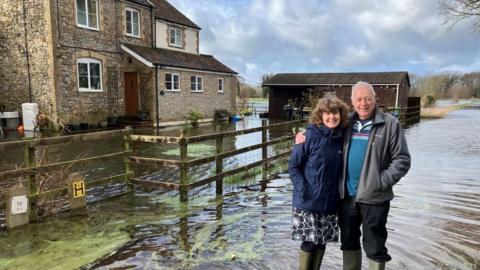 Mr and Mrs Smart stood outside their flooded property