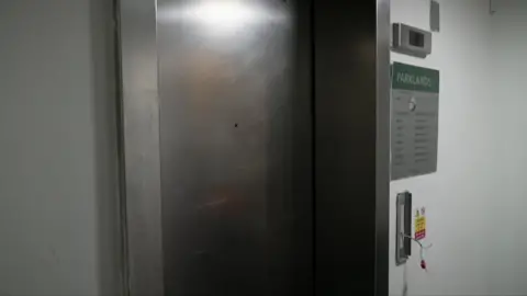 The picture shows a broken lift in one of the blocks of flats. Webaging is stacked from the control panel.