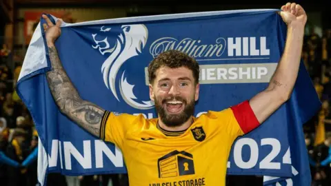 Jamie Brandon with the Scottish Premiership Play-off flag