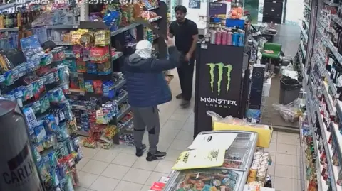 Bikrant Malhotra CCTV footage of a shop being robbed by a man with a knife in the air