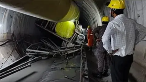 A view from inside the tunnel showing a boring machine turned upside down at the site of the roof collapse