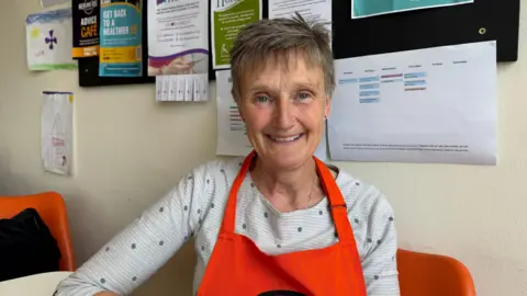 Debbie McLeod, a volunteer at the Banstead Pantry, looks straight at the camera.