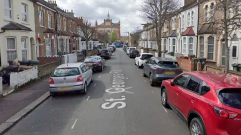 Google A Google street view image of part of St George's Road, with terraced houses and cars parked along both sides of the road. 