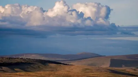 Ian Glendinning Northumberland's Cheviot Hills stretch out in all directions with no farms or roads visible. The sky is blue-grey and full of clouds 