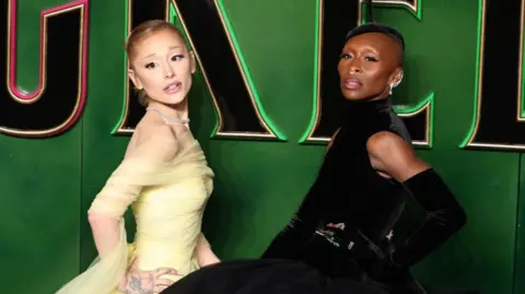 Getty Images Stars of Wicked, Ariana Grande and Cynthia Erivo, pose on the green carpet for the film