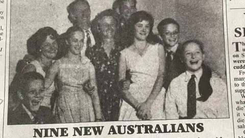 Newspaper cutting showing the MacDonald family after they arrived in Australia. They are laughing and smiling. The headline under the picture reads: 'Nine new Australians'.