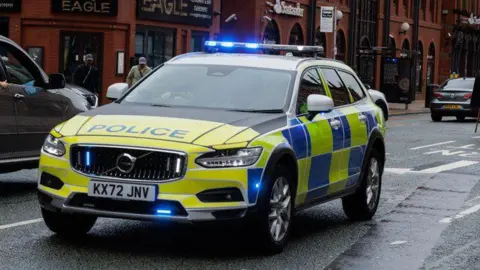 A police car in the middle of the road in Manchester City Centre