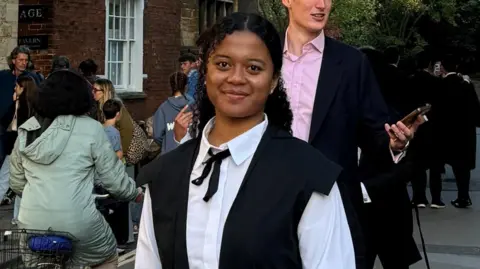 Victoria Tassongo Victoria pictured wearing smart clothes and smiling at the camera