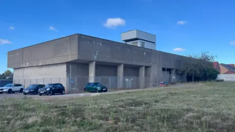 BBC Concrete war room building with cars outside the building