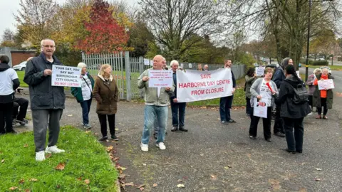 Protester holding banners outside former Harborne Day Centre in West Boulevard.