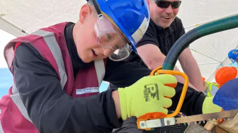 BBC Boy sawing wood 