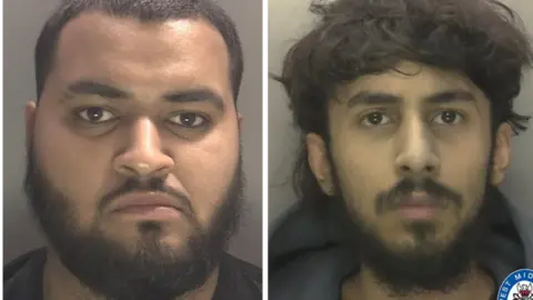 Side-by-side police custody images of two adult individuals facing forward against plain backgrounds; the left image shows a person with short hair and a full beard wearing a dark top, and the right image shows a person with longer, messy hair and light facial hair wearing a hoodie, with a West Midlands Police logo visible in the bottom right corner. 