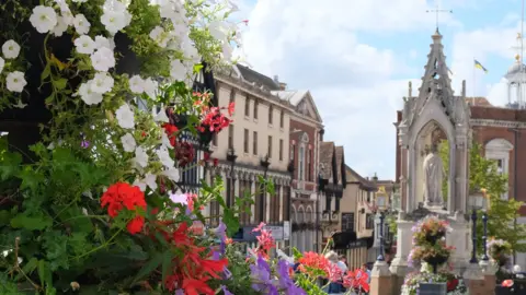 An image of Maidstone Town Centre. A floral display can be seen in the foreground of the image.