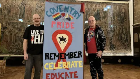 BBC Two men standing next to an Aids memorial quilt