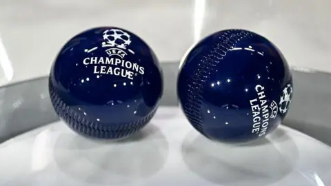 Two dark blue draw balls with the Uefa Champions League logo