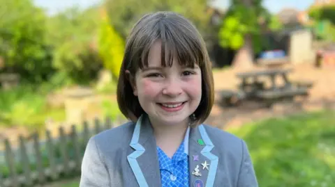 BBC/Kate Bradbrook Maisy - girl with dark bob and grey uniform