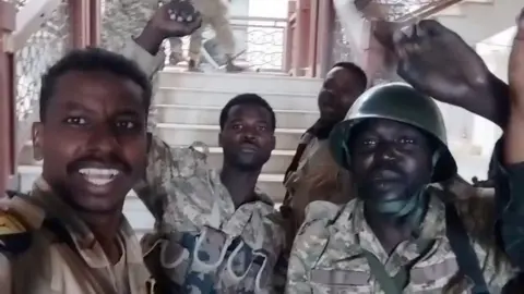 Reuters Sudanese army members film themselves inside the presidential palace after announcing they had recaptured it on Friday