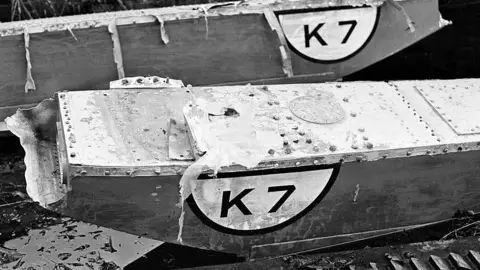 Mirrorpix via Getty Images Close-up of parts of Bluebird recovered from the lake following the crash. They both have a painted logo reading "K7".