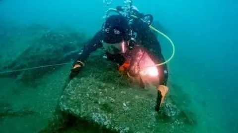 MSDS Marine Diver examining the Northumberland wreck wooden chest from the Northumberland wreck. 
