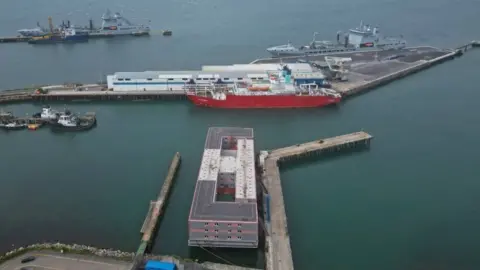 Reuters An aerial view shows the Bibby Stockholm barge moored at Portland Port.