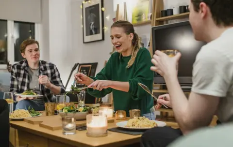 students sitting around a coffee table with food