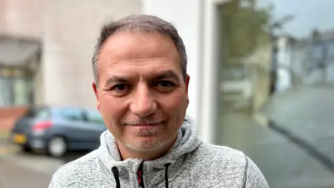 Tredegar mayor Kevin Phillips, wearing a grey top with drawstrings, standing looking at the camera in the town