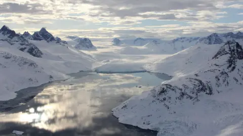 Reuters A fjord in southeast Greenland, shown with a marine-terminating glacier in the distance, is filled with open water.