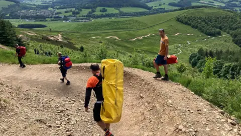 TVMRT A rescue team walks along the trail at Glentress in the Borders with hillside in the background