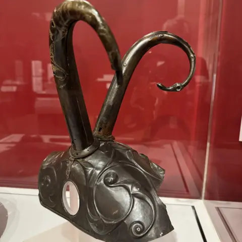 Harvard Art Museums An Iron Age pony cap with swirling decoration and two horns sticking out the top.