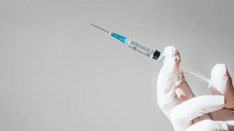 Getty Images A hand holding a syringe
