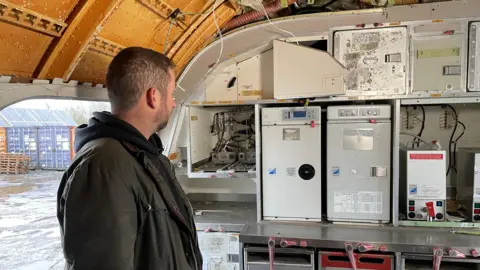 Man looking at kitchen equipment in an aircraft galle