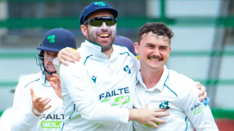 Andrew Balbirnie congratulates Matthew Humphreys after one of the spinner's six wickets in Zimbabwe's second innings in Bulawayo