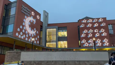 The Children's Hospital, decorated by a giant moon made of lights and several smaller stars. All around both are plaques to commemorate the sponsors for the campaign.