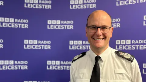 A man in glasses in a police uniform