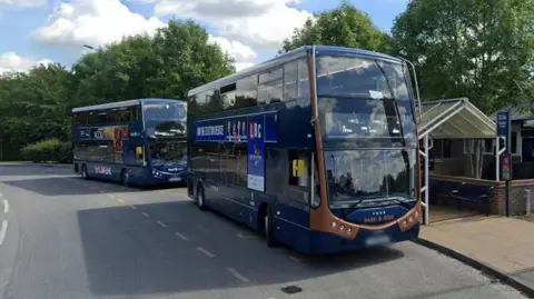 Two blue double-decker buses are stopped at a bus shelter. Both have York Park and Ride logos.