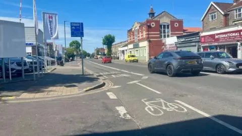 A cycle lane going into a bus lane on Fishponds Road, which is a busy road with cars.