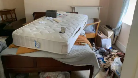 Family photo Bed and rubbish all over the place in a bedroom