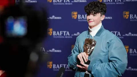 Getty Images Owen Cooper, winner of the Supporting Actor Award for 'Adolescence', poses backstage during the 2026 BAFTA Television Awards with P&O Cruises at The Royal Festival Hall on May 10, 2026 