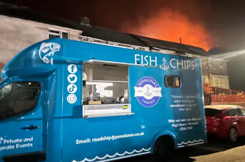 Penaluna Fish and Chips Penaluna fish and chip van from Hirwaun parked on a street as firefighters tackle a wildfire blaze on the nearby Rhigos mountain