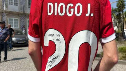 Sofia Ferreira Santos/BBC A red Liverpool shirt with the number 20, name 'Diogo J.' and a small autograph that reads: Um abraço para o Fábio