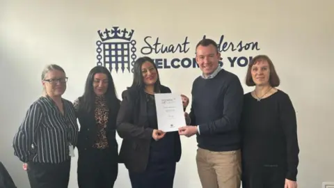 Stuart Anderson MP Leanne McDonald receives her award from MP Stuart Anderson