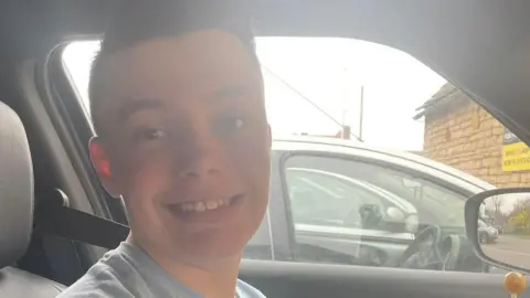 Tammy Noah, a boy with short black hair, smiling for camera.