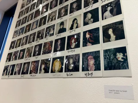 A collage of dozens of Polaroid photographs of wigs Sarah Wood has made.