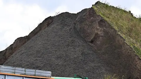 The mound of material on Simonswood Industrial Estate