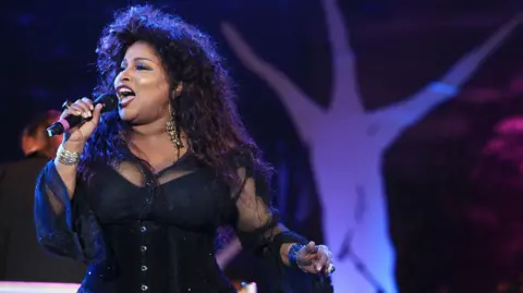 Chaka Khan on stage singing into a microphone