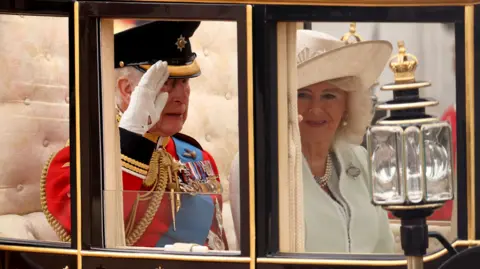 Reuters The King salutes from inside his carriage while sitting next to the Queen