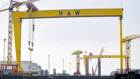 PA Media The famous yellow Harland and Wolff cranes set against a grey cloudy sky